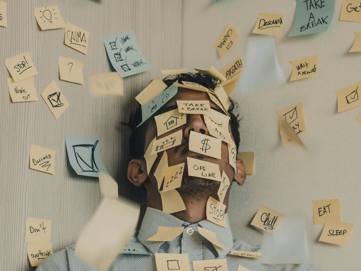 A man with his face and shirt covered in sticky notes